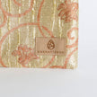 Shimmery gold zip pouch with 'Unshattered' brand label on a white background