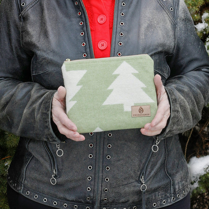 A woman holding a christmas style fabric zip pouch named after Vincent 