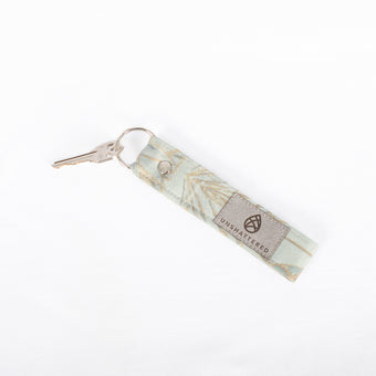 A loop keychain with a damask pattern design, featuring a silver-tone keyring and upcycled fabric named after Keisha.