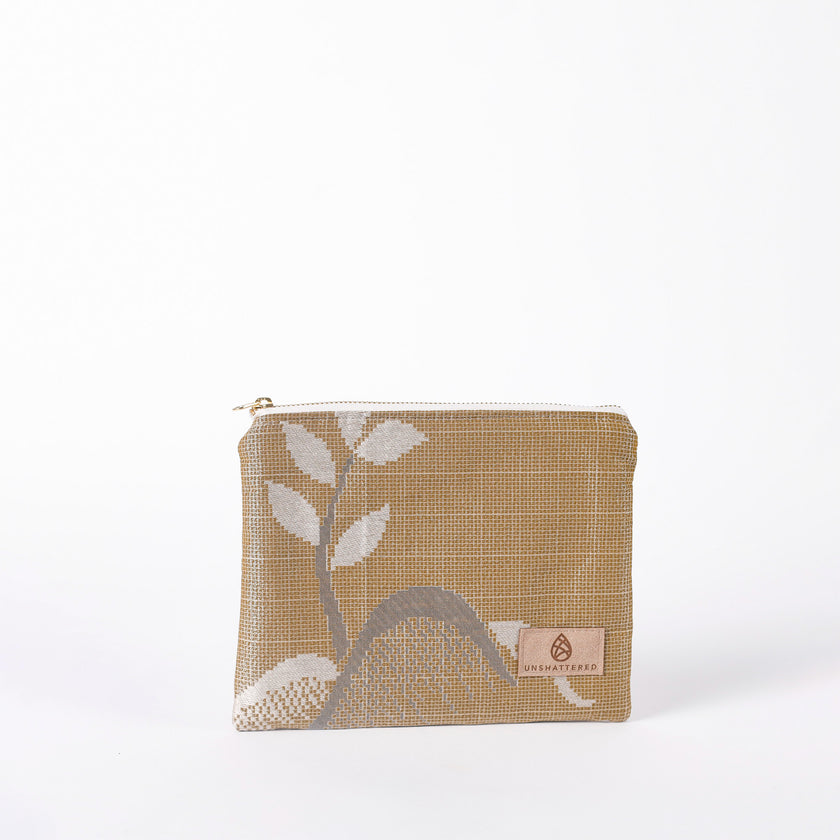Beige pouch with leaf design on a white background