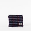 A dark blue zip pouch with a vibrant pattern of colorful short lines, featuring a zip closure and a label with a brand logo named after Keri