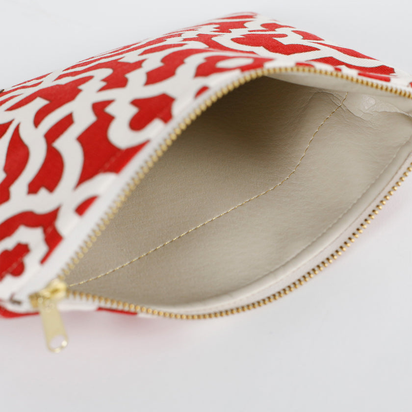 A taupe wipe-clean interior on a red and white design zip pouch 