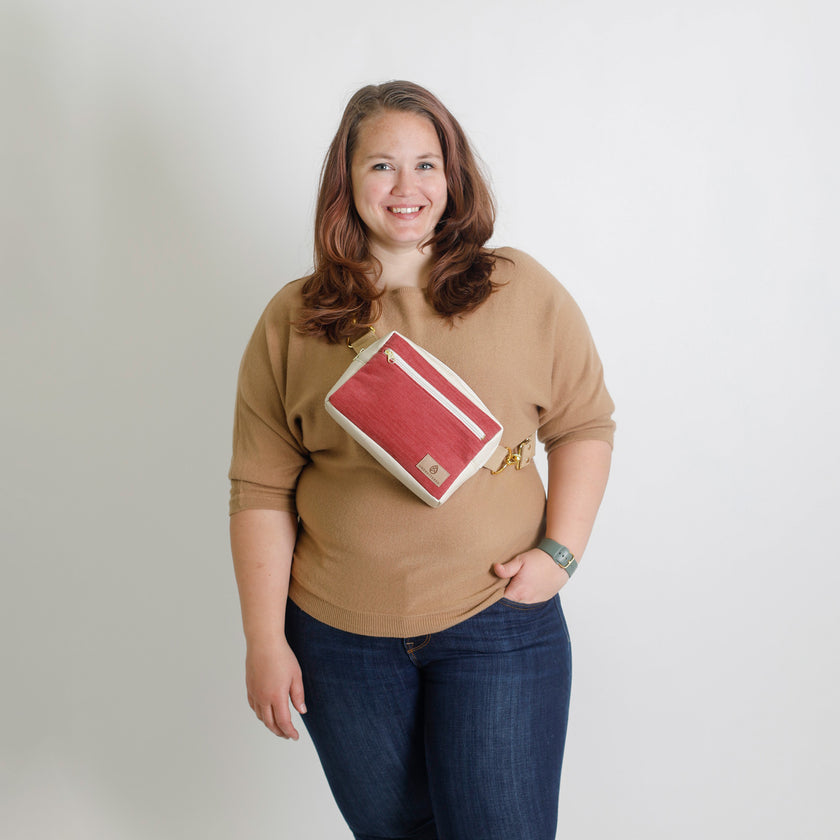 Woman holding a red and white bag against a plain background named after Korin 