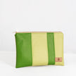 A green multi-panel zip pouch with a visible brand tag showing on the lower right corner, with a zip closure and gold-tone hardware named after Krista.