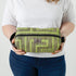 A woman holding a lime green geometric pattern toiletry kit with a gray Unshattered label named after Kristie