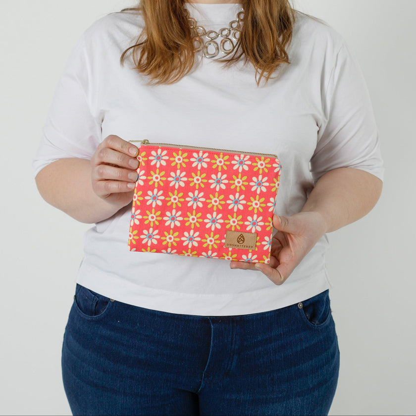 Person holding a pink floral zip pouch against a plain background named after Krystal 