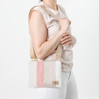 Woman holding a white and pink handbag against a plain background named after Alyssa