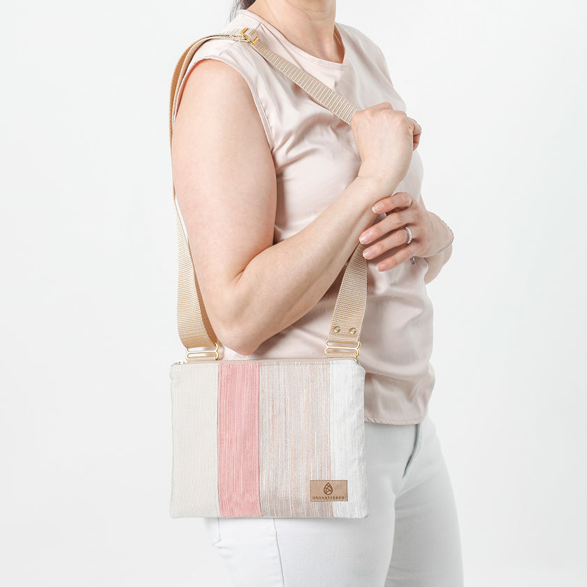 Woman holding a white and pink handbag against a plain background named after Alyssa