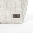 A suede gray label on a white twill weave makeup bag by Unshattered