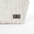 A suede gray label on a white twill weave makeup bag by Unshattered