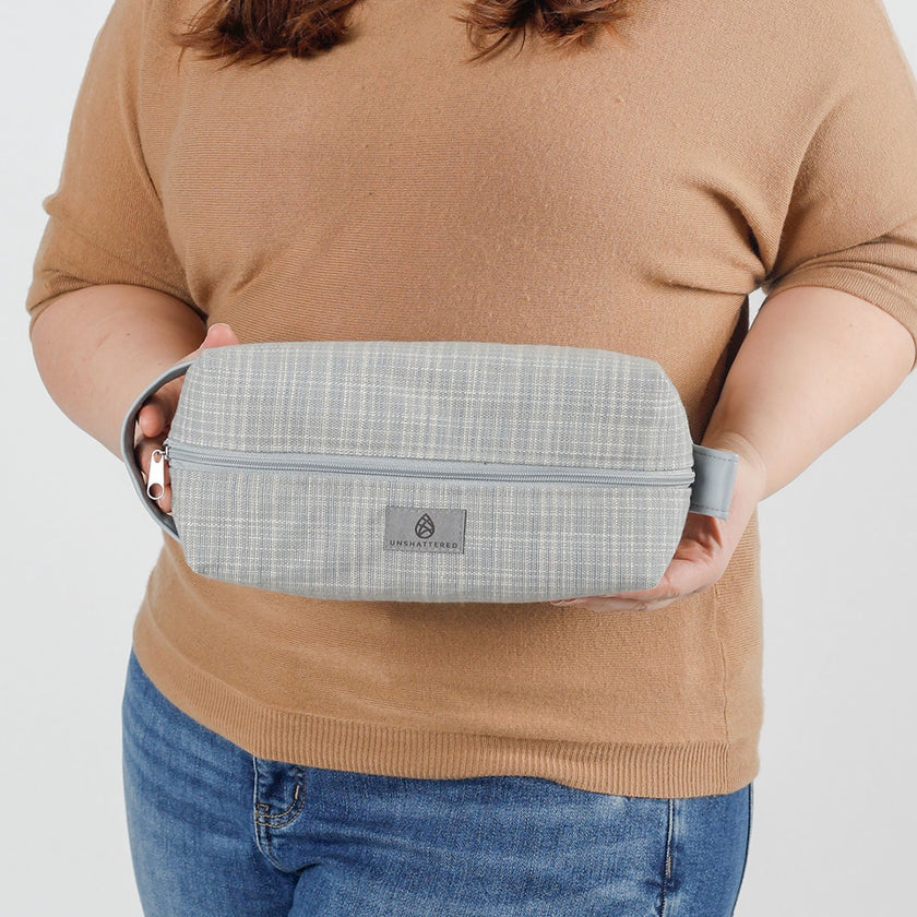 Woman holding a blue checkered toiletry kit named after Latisha 