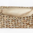 A close-up view of the interior of an upcycled toiletry kit, featuring a cream-colored luxury leather alternative lining accented by elegant gold-toned stitching.