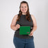 A woman smiling while holding a textured green fabric zip pouch featuring a gray label and a matching gray zipper.