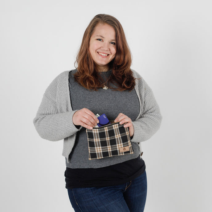 Woman holding a plaid pouch with a white background named after Jeyana