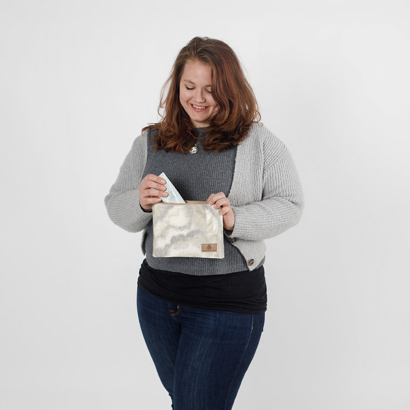 Woman putting product in the Billy pouch made from upcycled materials by Unshattered