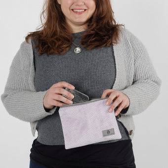 A woman holding a purple plush zip pouch named after Jaimilee