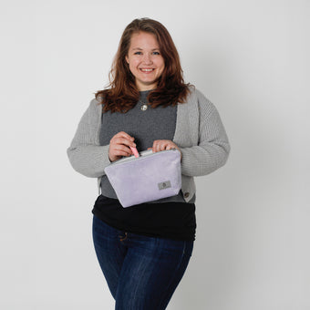 Woman holding a purple makeup against a plain background named after Jamar 