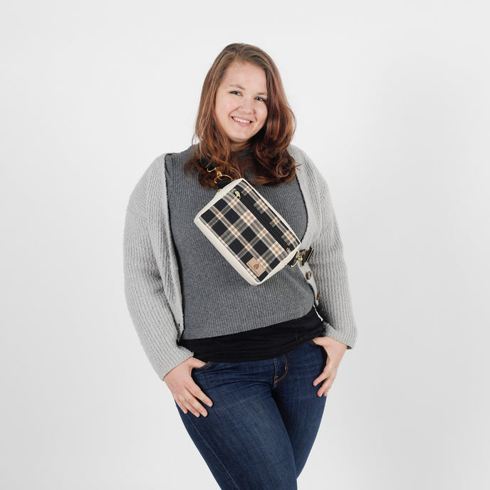 Woman wearing a gray sweater with a plaid bag over her shoulder on a white background named after Jesus