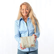 Woman holding a  striped zip pouch against a plain background named after Sherry 