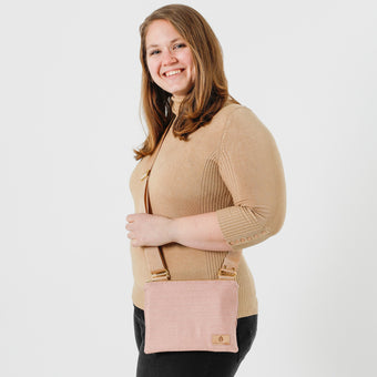 A woman wearing a tan turtleneck carrying a pink lined fabric crossbody bag names after Lakeysha