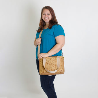 A woman carrying a yellow design convertible handbag named after Quadira