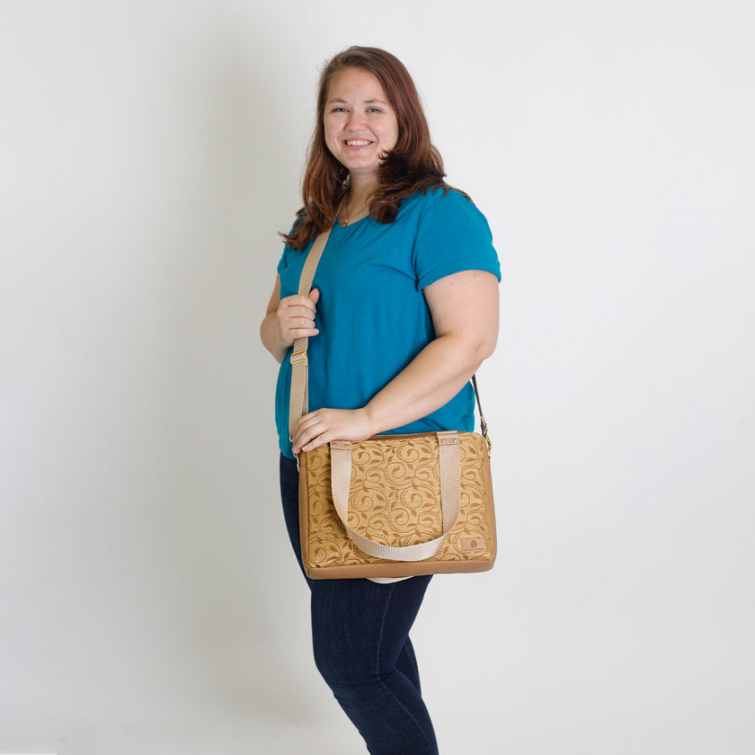 A woman carrying a yellow design convertible handbag named after Quadira