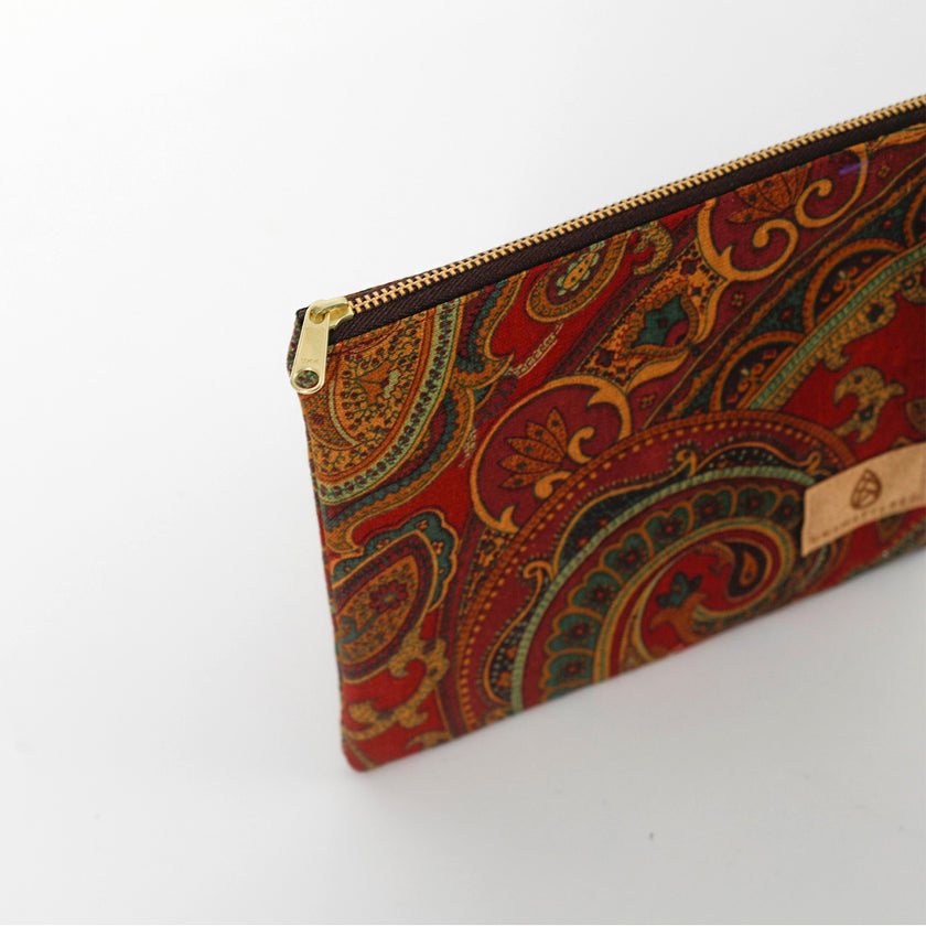Colorful paisley-patterned pouch with a gold zipper on a white background named after Liliana