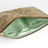 A mint green interior with a gold tone zipper on a tan floral large zip pouch on the exterior