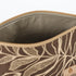 Beige wipe-clean interior of a brown leaf patterned fabric makeup bag on a white background. 