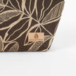 Tan suede Unshattered label on a brown leaf patterned fabric makeup bag named after Lizzie