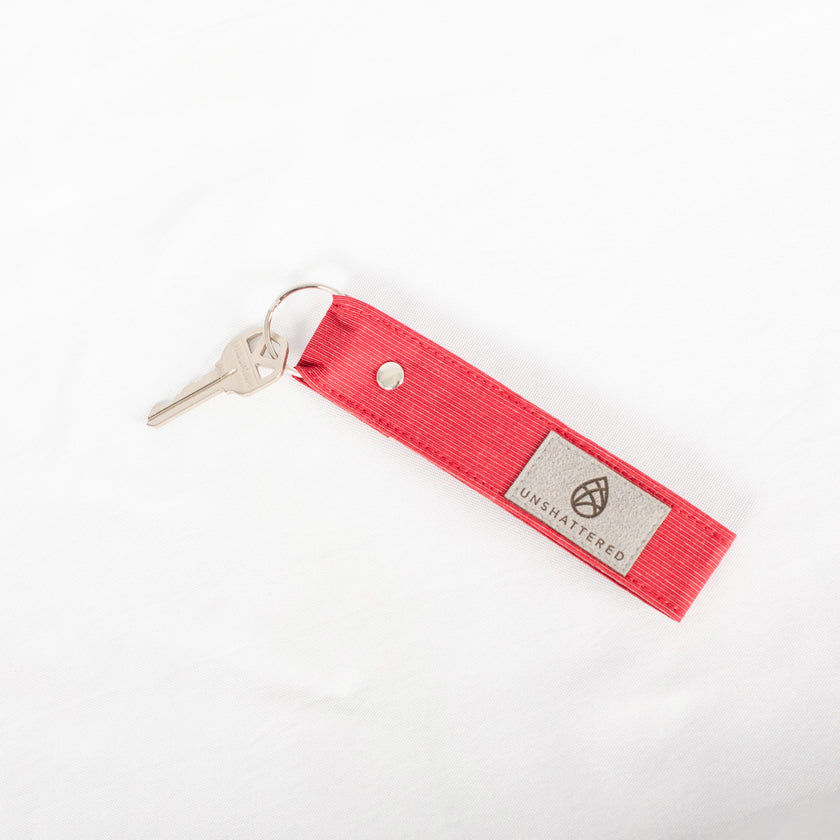 A red keychain with a silver-tone keyring and a loop, named after Lolo