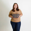 Woman holding a colorful patterned pouch against a plain background named after Luisa 