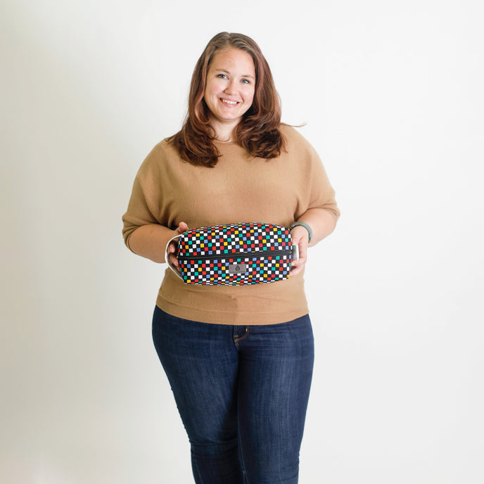 Person holding a colorful patterned bag against a white background named after Lyddin 
