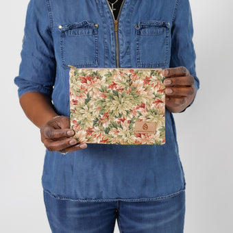Hands holding a leaf design zip pouch wearing a jean shirt  named after Lynette