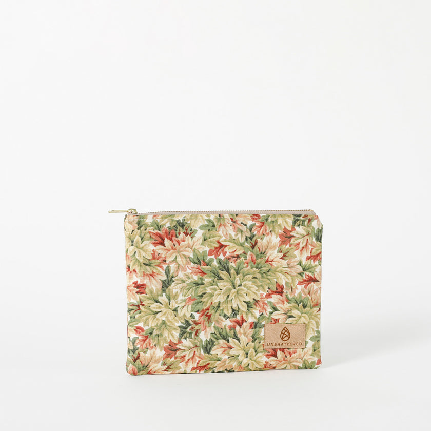 A floral patterned zip pouch with a gold-tone zipper, upcycled fabric named after Lynette