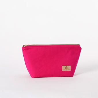 Hot pink makeup kit with a gold zipper and brand label on a white background