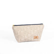 Makeup bag made from upcycled metallic beige fabric with navy zipper on a white background