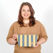 A woman holding a yellow and blue design makeup kit bag named after Malika