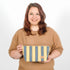 A woman holding a yellow and blue design makeup kit bag named after Malika