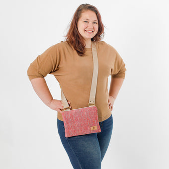 Woman holding a pink crossbody bag against a white background
