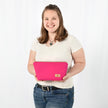 Person holding a hot pink makeup kit against a white background
