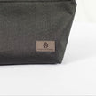 A gray label on a black makeup bag made by outdoor furniture material 