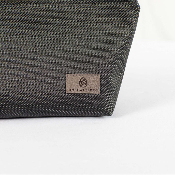 A gray label on a black makeup bag made by outdoor furniture material 