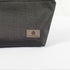A gray label on a black makeup bag made by outdoor furniture material 