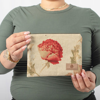 A woman holding a tan flower zip pouch with a tan label 