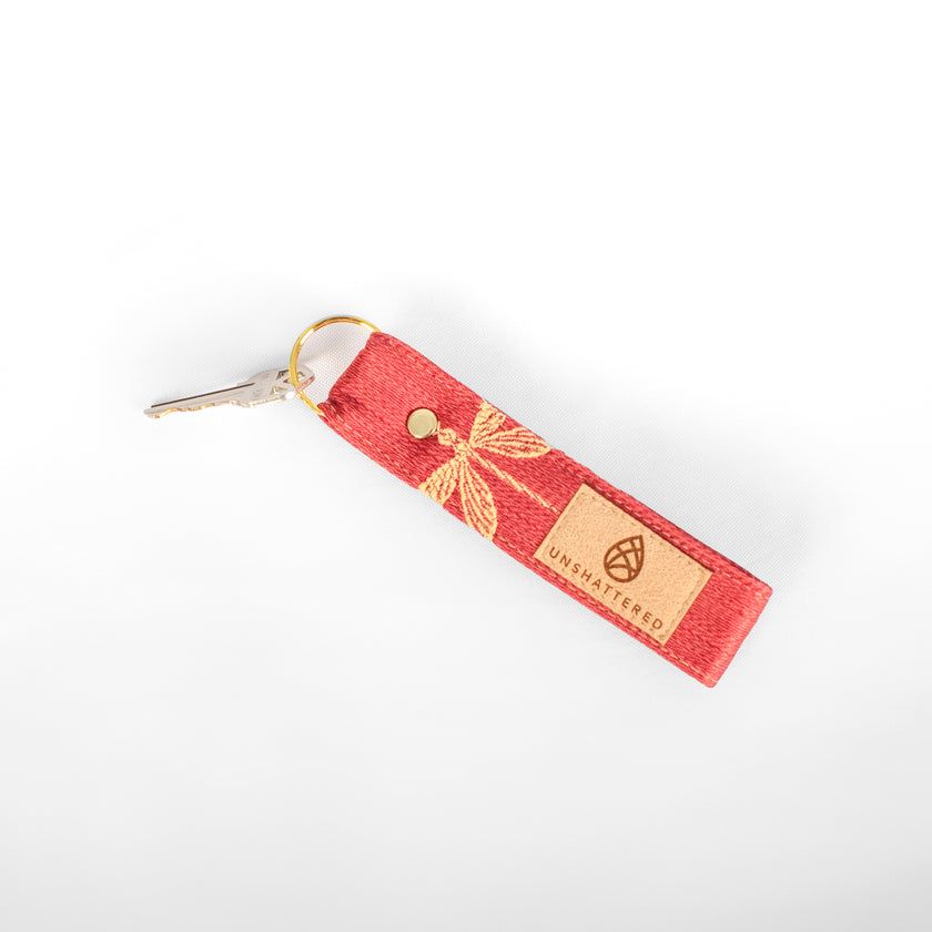 Red keychain with gold accents on a white background