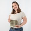 Person holding a plaid bag against a white background