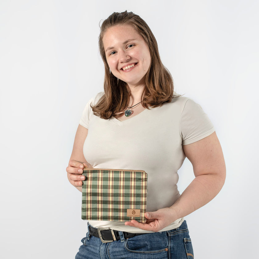 Person holding a plaid bag against a white background