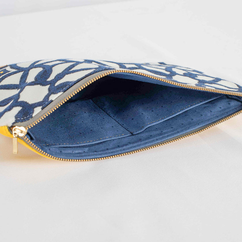 A blue fabric interior with dots on a white and blue large zip pouch design 