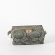 A green and brown geometric patterned toiletry kit with a white zipper and a brand tag 